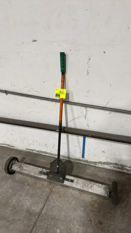 Magnetic roller sweeper. Features an aluminum housing, long push handle with grip, and two rolling wheels. 36"W.
