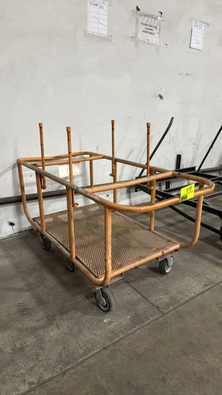 Metal 6-wheel platform cart. Features an orange tubular steel frame, expanded metal mesh deck, and (4) vertical upright dividers. Dimensions: 69"L x 2