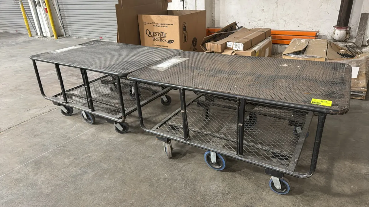 Metal 6-wheel carts. Features perforated metal top surface, expanded metal lower shelf, and tubular steel frame construction. Dimensions: 64" x 39". M