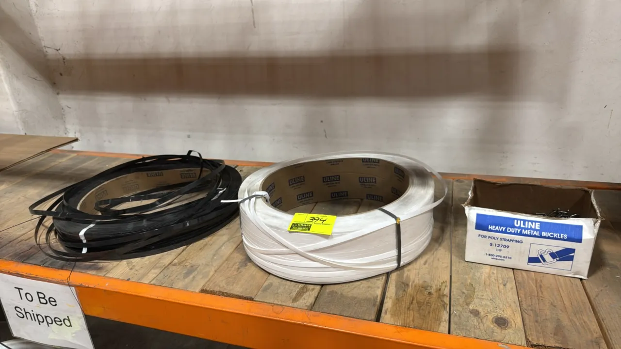 Uline poly strapping and buckles lot. Includes (1) roll of white plastic strapping, (1) roll of black plastic strapping, and (1) partial box of S-1270