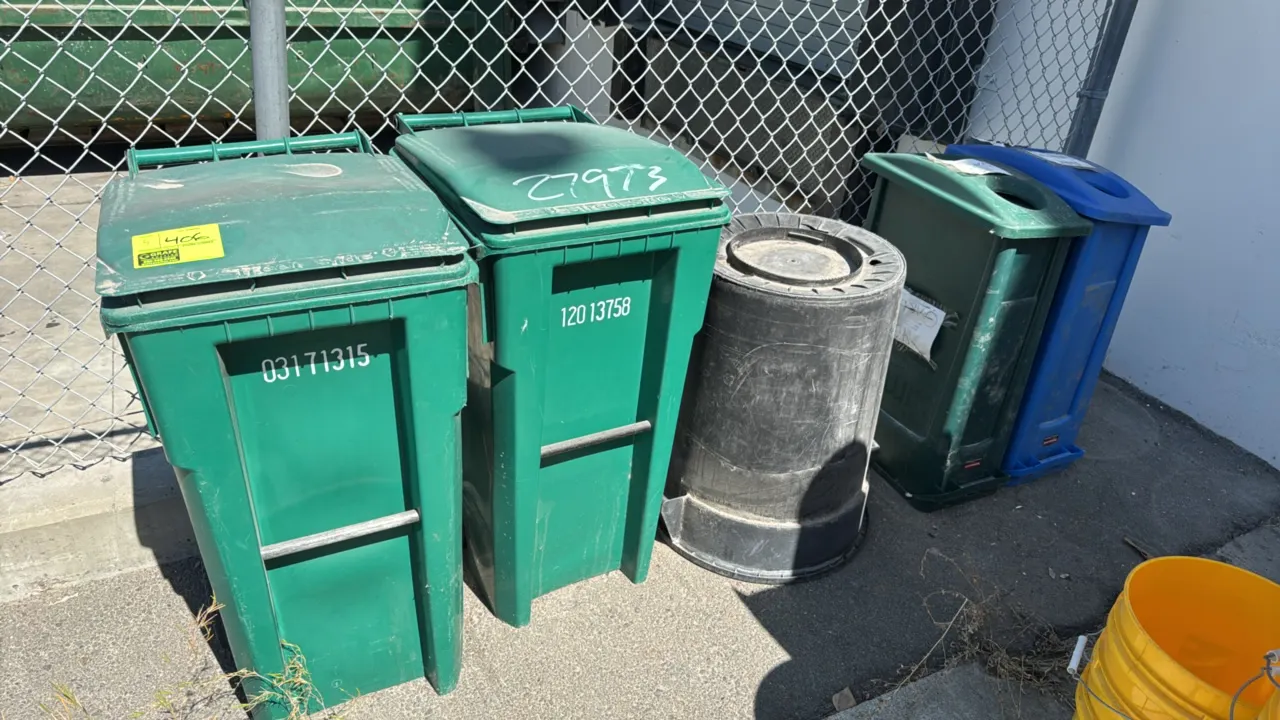 Assorted polyethylene trash cans and recycling receptacles. Includes green rollout wheeled carts with attached hinged lids, a round black poly contain