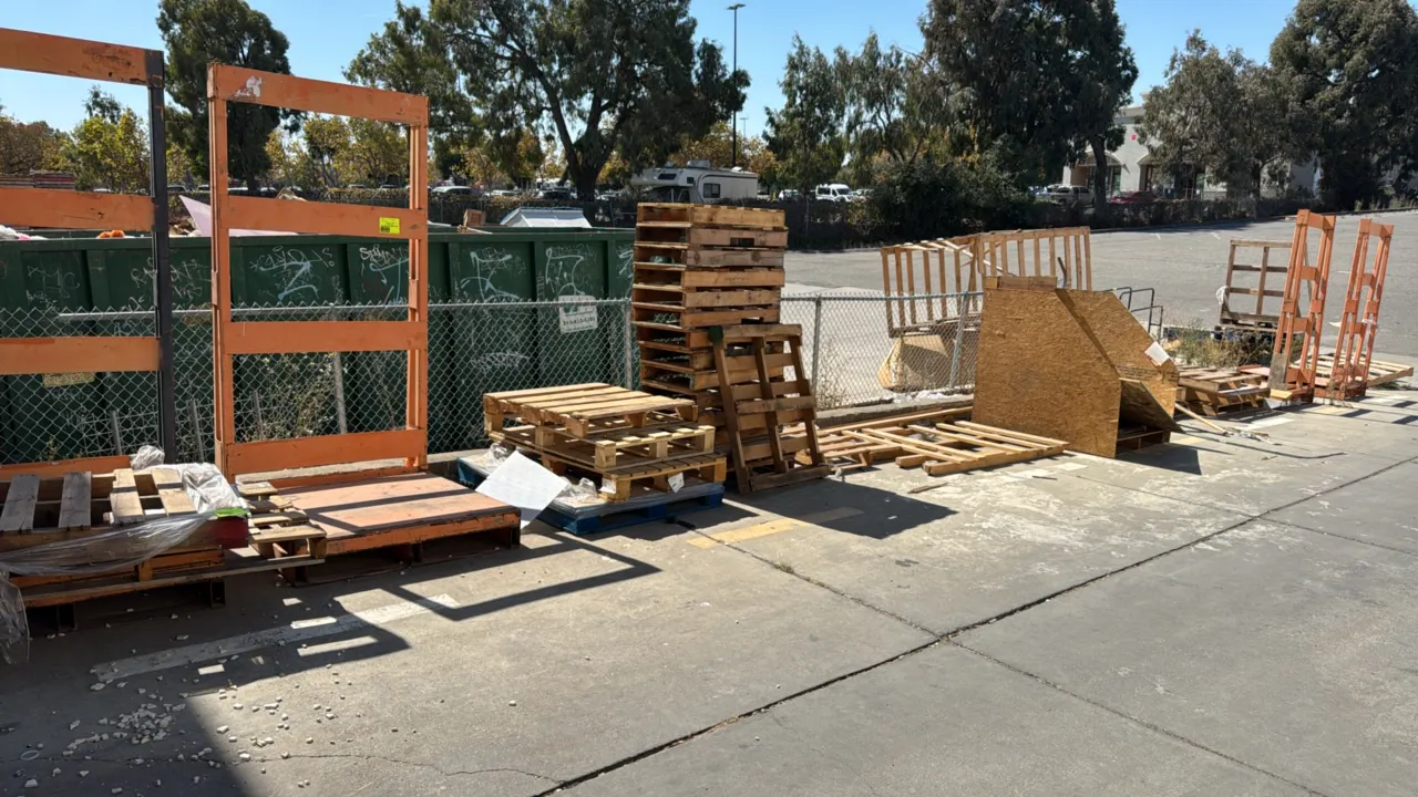 Bulk lot of assorted wooden pallets, wood bin, and scrap lumber. Includes various sized wooden shipping pallets, wood frame crate structure, OSB wood