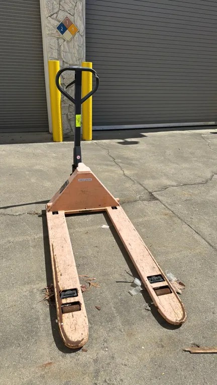 Uline pallet jack. Features 3,300 lb capacity, loop handle with release lever, and manual hydraulic pump. Note: Unit is marked as needing work.