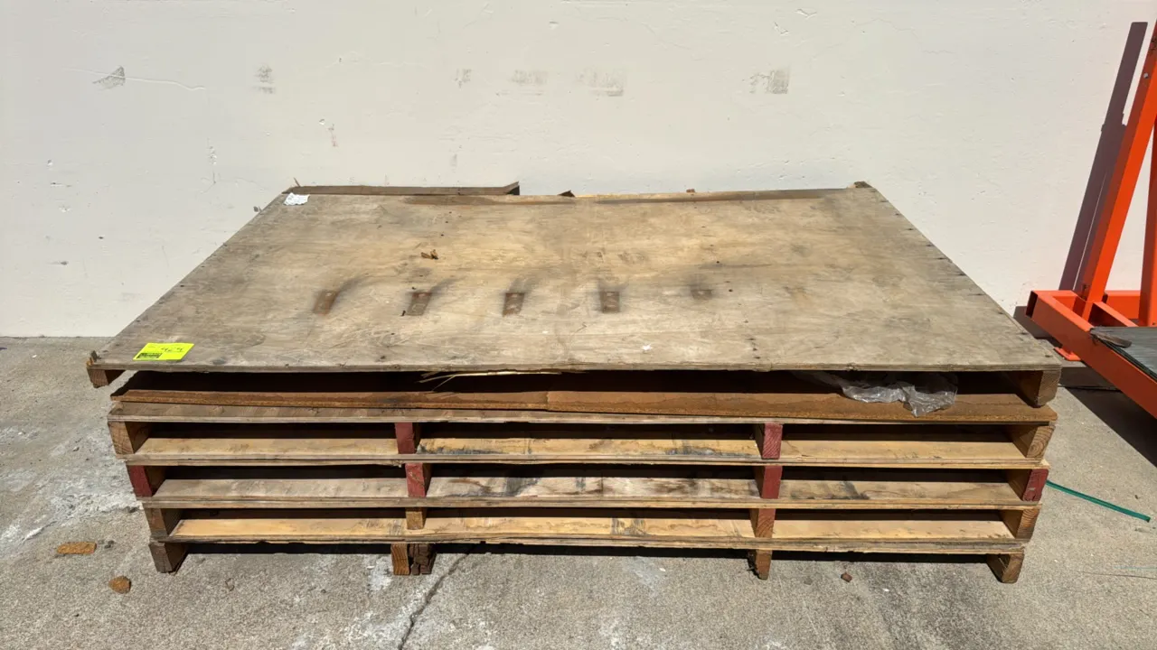 Stack of wood pallets. Features plywood top decking and dimensional lumber runners with forklift access openings. Dimensions: 82" x 52".