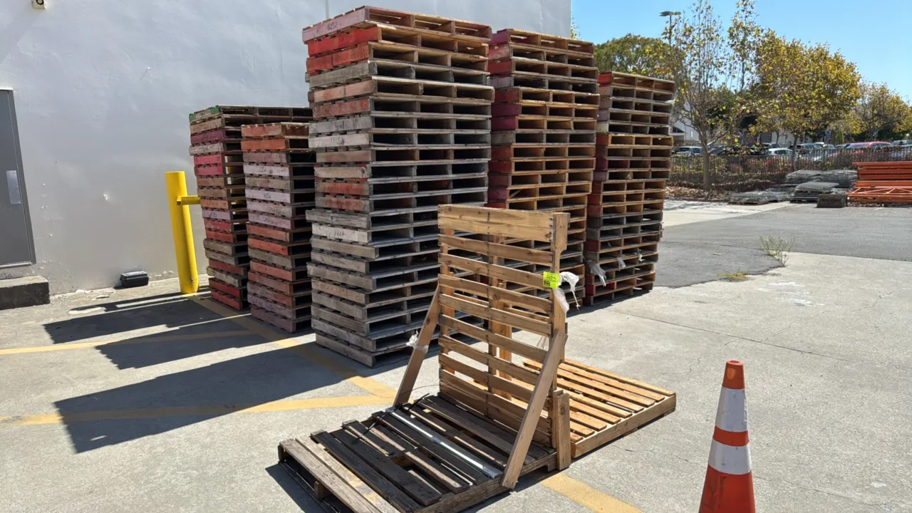 Bulk lot of assorted wooden pallets. Features multiple stacks of standard warehouse stringer and block pallets in mixed conditions and finishes, inclu