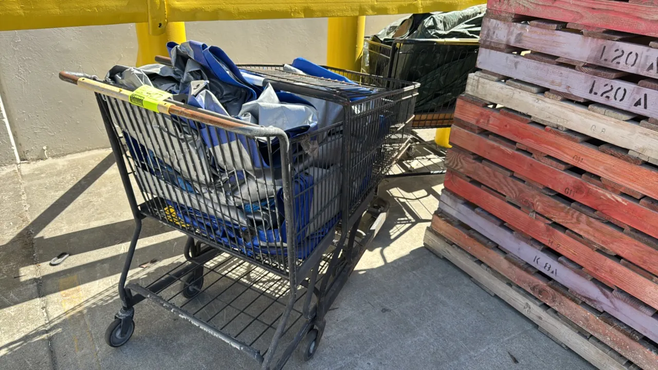 Package lot of assorted tarps with (2) metal shopping carts. Includes various heavy-duty poly tarps in blue, silver, and green. Shopping carts feature