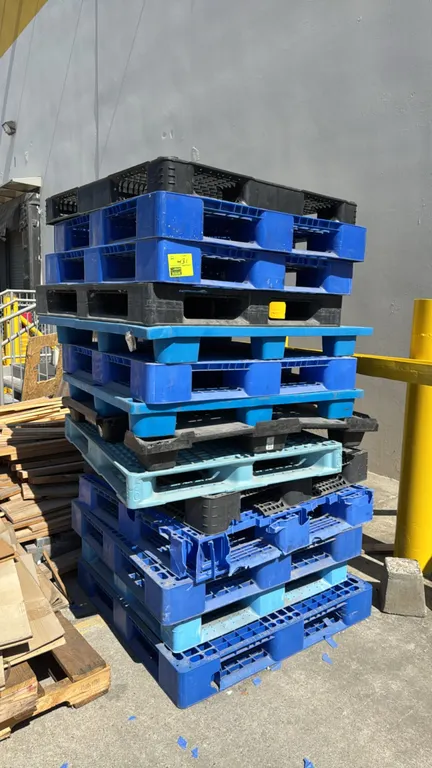 Bulk lot of poly pallets. Includes assorted plastic pallets in blue and black. Features 4-way and 2-way forklift entry. Note: Some units show damage,