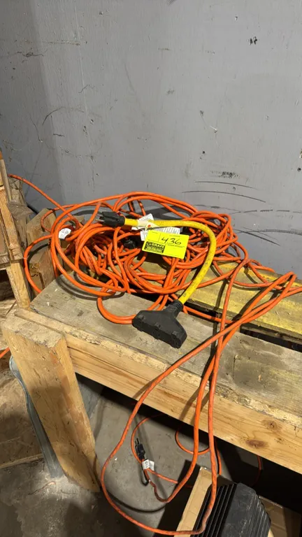 Assorted extension cords. Includes orange extension cord and a yellow 3-outlet power adapter cord. Features standard 3-prong grounded plugs and recept