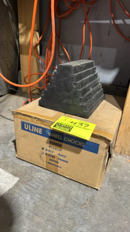 Uline H-517 rubber wheel chocks. Features molded black rubber construction with stepped ribbed traction surface. Dimensions: 9 3/4" x 8" x 6".