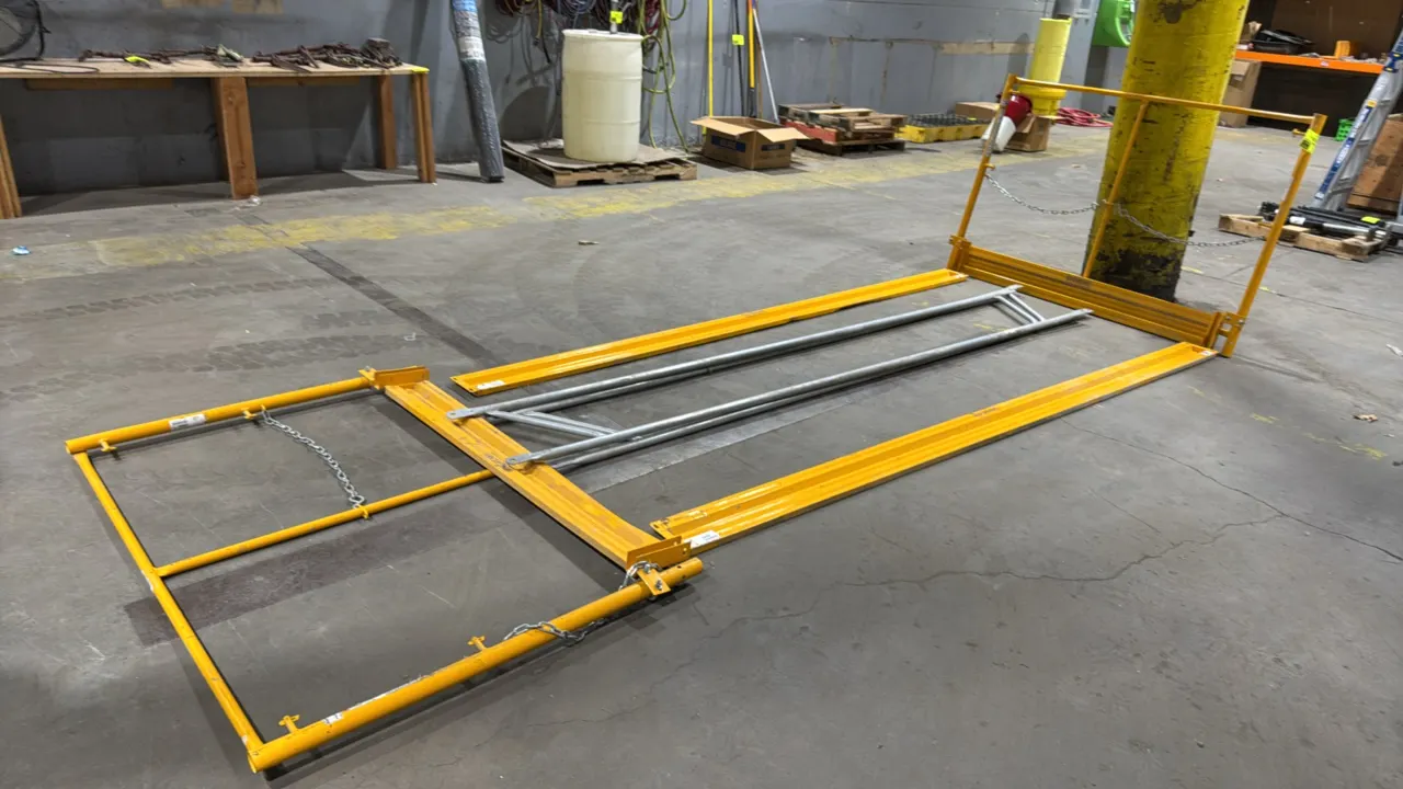 Haulotte Bil-Jax Ez Guard metal guardrail system. Features yellow powder-coated tubular end panels with safety chain closures, yellow steel side toebo