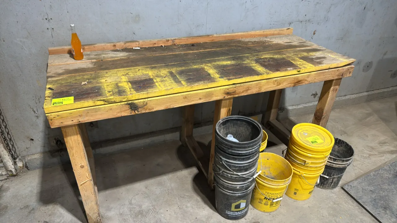 Wood workbench. Features dimensional lumber construction, plank work surface, and a raised rear lip. 84" x 32" x 42". Buckets and contents not include