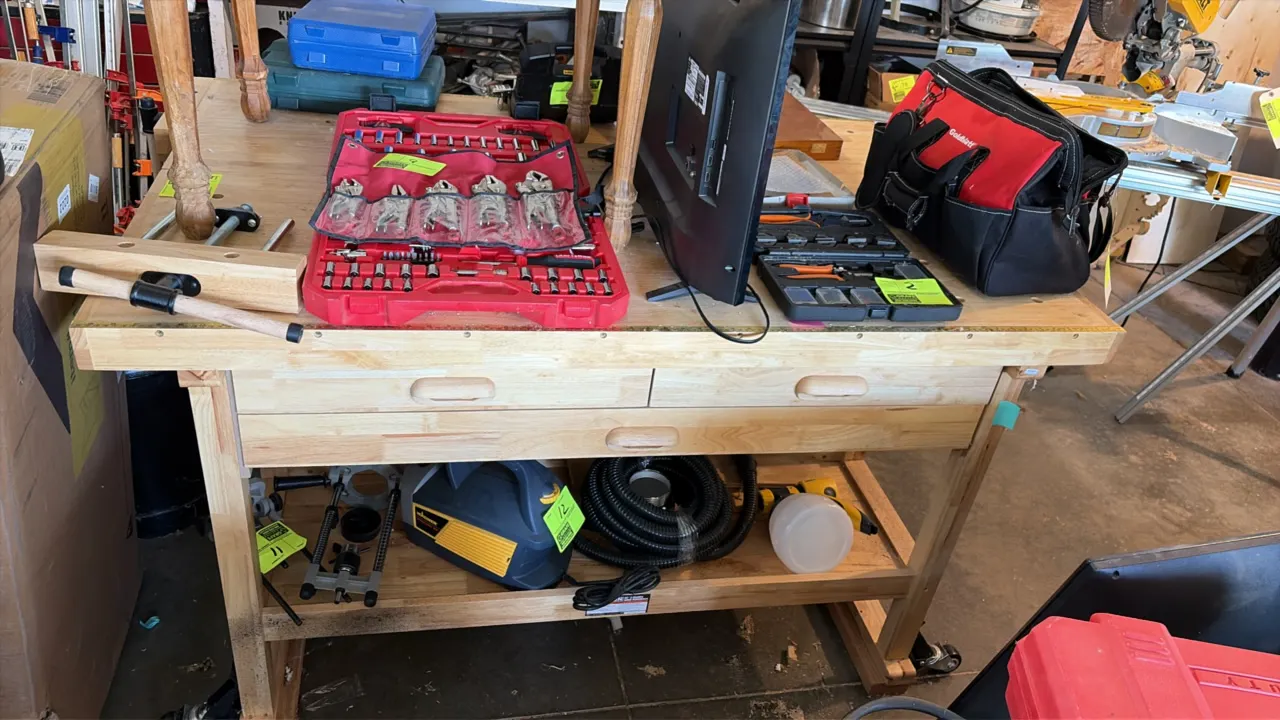 Wood double-sided workbench. Features hardwood construction, integrated wood vise, drawers on both sides, and a lower storage shelf. Includes contents
