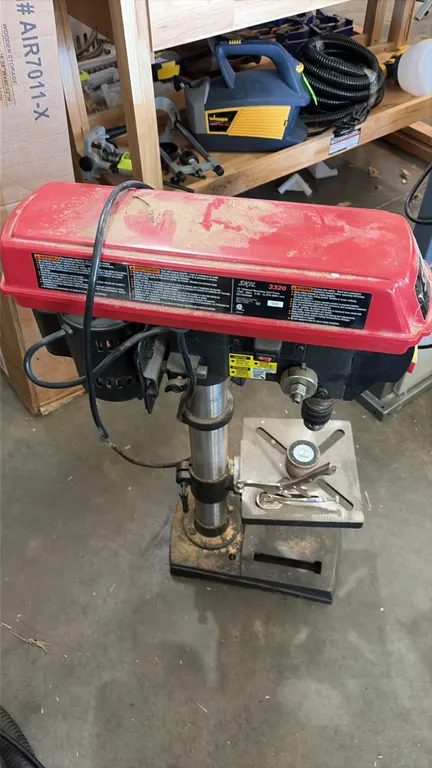 Skil 3320 10" benchtop drill press. Features an adjustable slotted work table, 3-spoke downfeed handle, and safety power switch. Speed range: 570-3,05