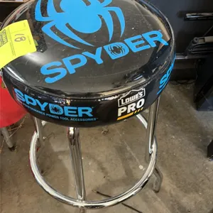 Spyder shop stool. Features a round padded vinyl seat with Spyder and Lowe's Pro branding. Mounted on a chrome tubular steel frame with a circular foo