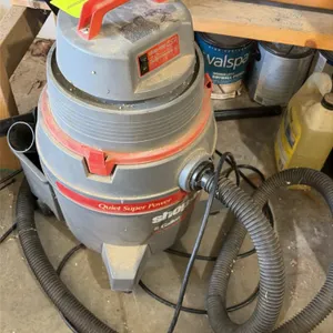 Shop-Vac QSP 8-gallon wet/dry vacuum. Features a 2.0 peak HP motor, top carry handle, flexible hose, and rear accessory storage. Mounted on casters.