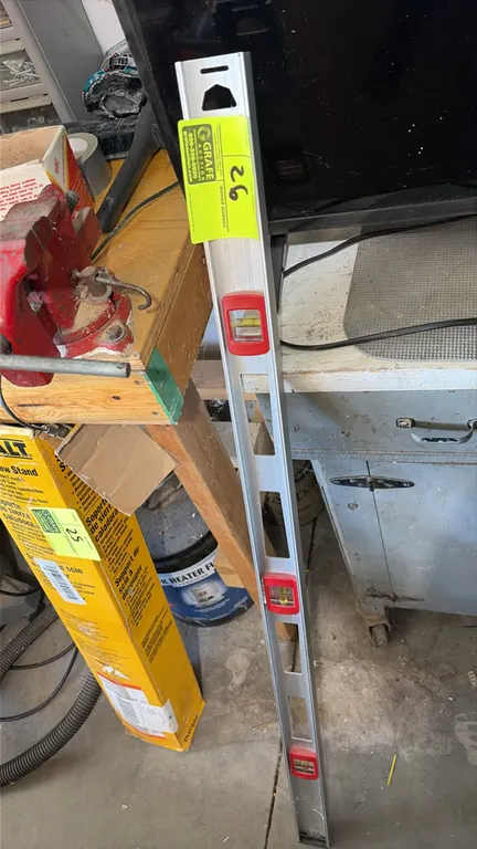 Aluminum level. Features three bubble vials, integrated hand grips, and a hang hole. 4'L. Workbench, vise, and surrounding items not included.