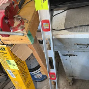 Aluminum level. Features three bubble vials, integrated hand grips, and a hang hole. 4'L. Workbench, vise, and surrounding items not included.