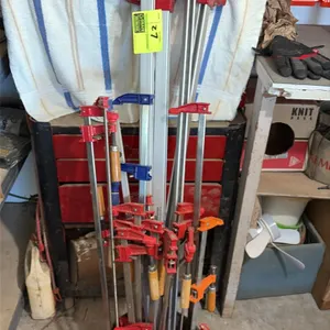 Assorted woodworking bar clamps. Features various styles and lengths including steel F-clamps, aluminum bar clamps, and parallel jaw clamps with woode