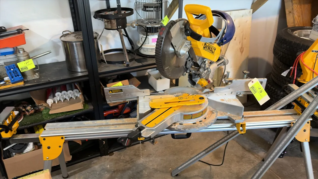 DeWalt sliding compound miter saw. Features sliding rails, rotating miter table, blade guard, and dust collection port. Includes folding miter saw sta