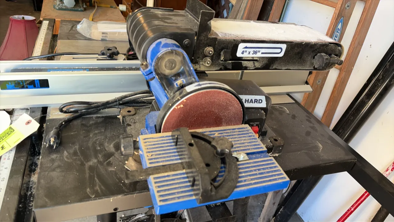 Delta belt and disc sander. Features a 4" x 36" sanding belt, 6" sanding disc, tilting work table with miter gauge, and dust collection port. Disc spe