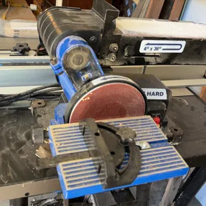 Delta belt and disc sander. Features a 4" x 36" sanding belt, 6" sanding disc, tilting work table with miter gauge, and dust collection port. Disc spe