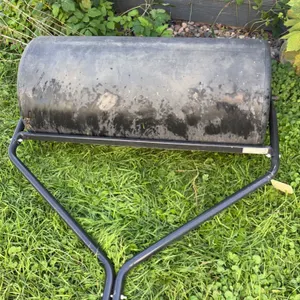 Agri-Fab tow-behind lawn roller. Features black poly drum with fill plug, tubular steel frame, integrated scraper bar, and hitch bracket. 36"W.