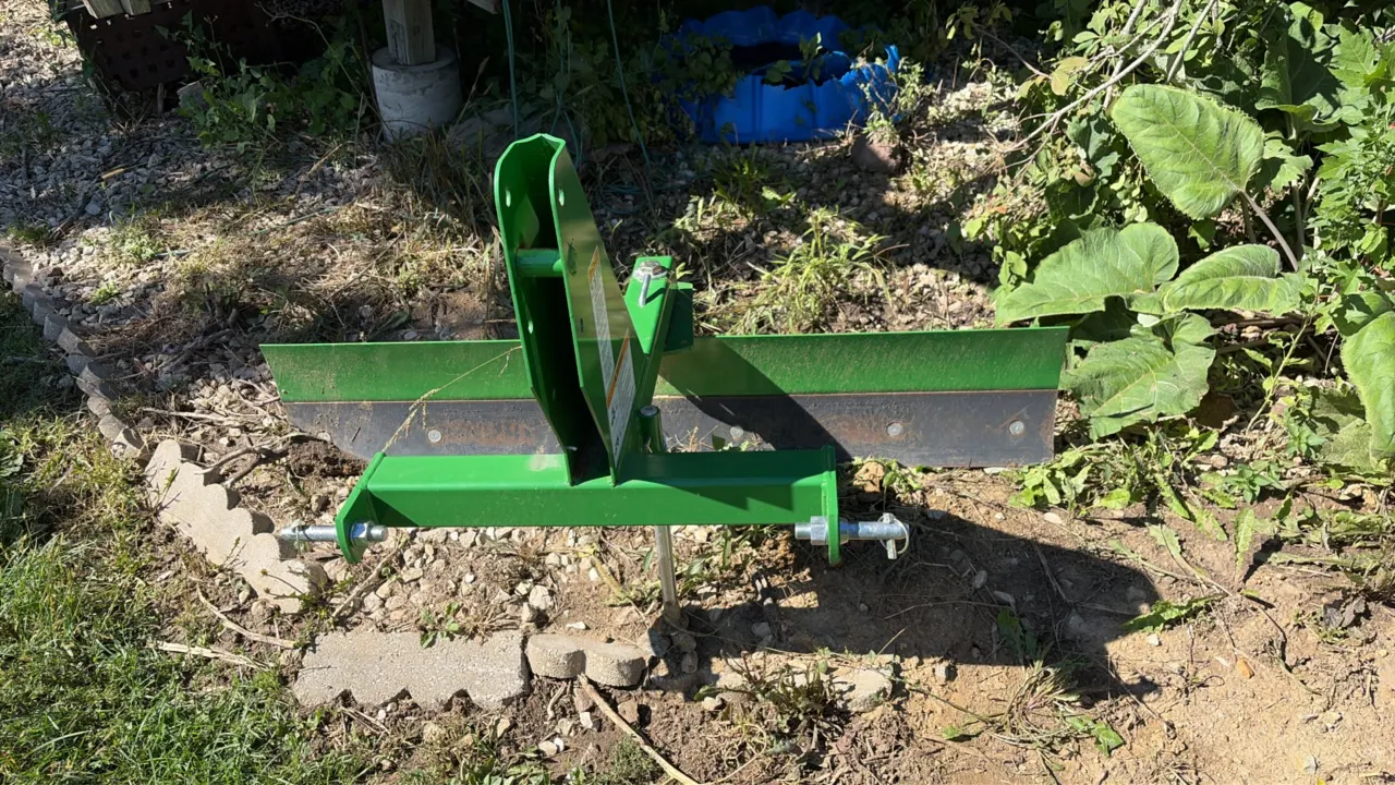 John Deere Frontier RB2060L 60" rear scraper blade. Features 3-point hitch mounting with hitch pins, multi-position angle adjustment, reversible cutti
