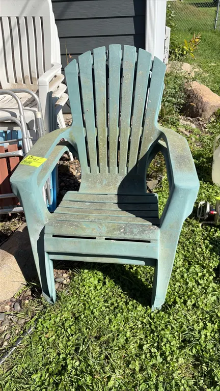 Assorted lawn chairs. Includes molded plastic Adirondack-style chairs, stackable resin patio armchairs, and aluminum folding lawn chairs with wood sla