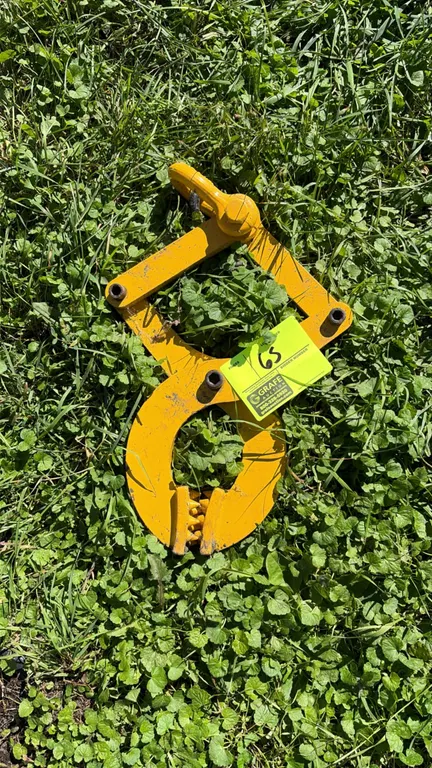 Steel pallet puller clamp. Features scissor-action mechanism, serrated gripping teeth, and top pulling ring.