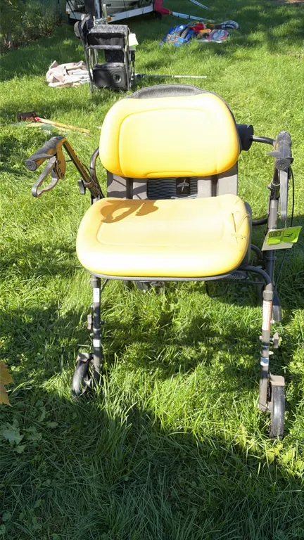Medline adjustable rollator walker. Features an attached John Deere yellow seat, ergonomic hand brakes, under-seat fabric storage pouch, and 4-wheel b