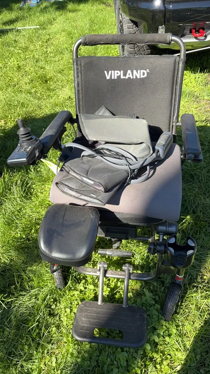 Vipland electric wheelchair. Features joystick control, padded seat, folding footrest, elevating calf rest, and cup holder. Includes air compression l