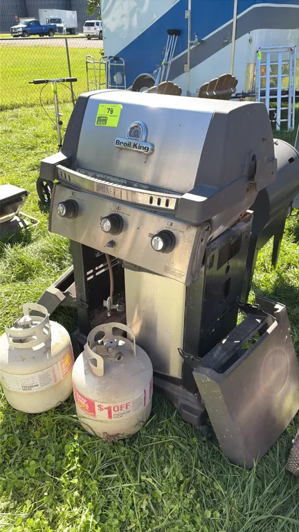 Broil King Signet 3-burner liquid propane gas grill. Features a stainless steel and cast aluminum hood with built-in temperature gauge, cooking grates