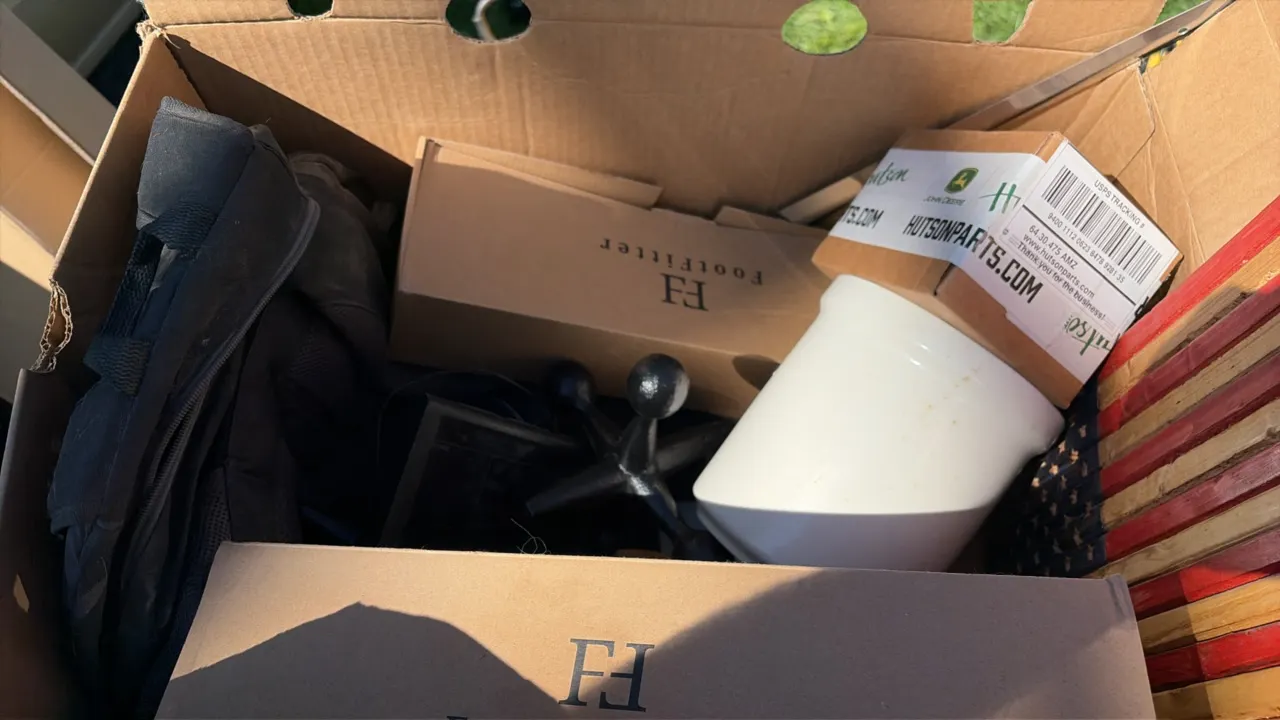 Assorted estate lot. Includes FootFitter wooden shoe stretchers with boxes, boxed John Deere parts, a backpack, cast metal decorative jack, white cera
