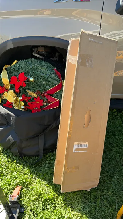 Wondershop 7' Balsam Fir pre-lit artificial Christmas tree. Includes artificial holiday wreath adorned with faux red poinsettias, gold ribbon, and rou