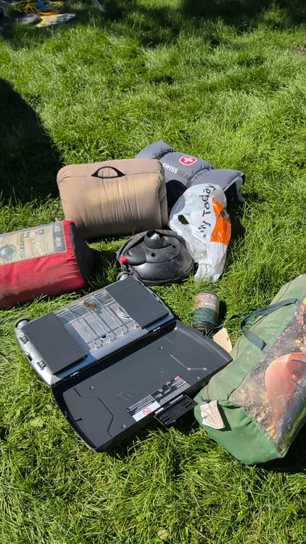 Assorted camping equipment package. Includes a Coleman 2-burner propane camp stove, Coleman Ozone 8-person tent measuring 15.5' x 12' in carry bag, (3