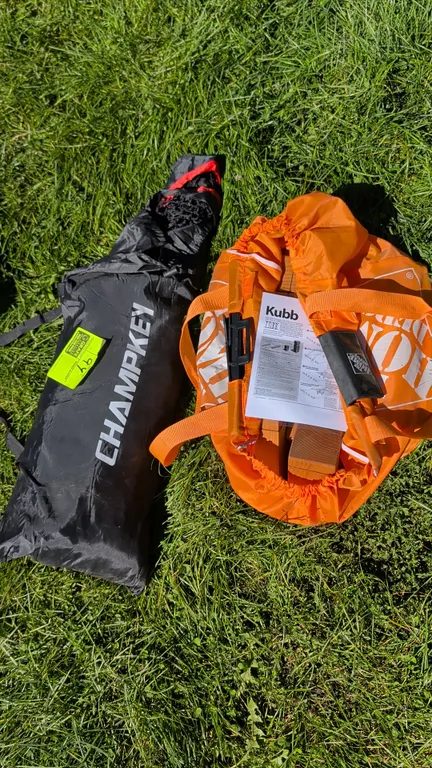 Champkey sports net set and wooden Kubb lawn game set. Includes Champkey net in carrying bag and wooden Kubb pieces in orange Home Depot tote bag with