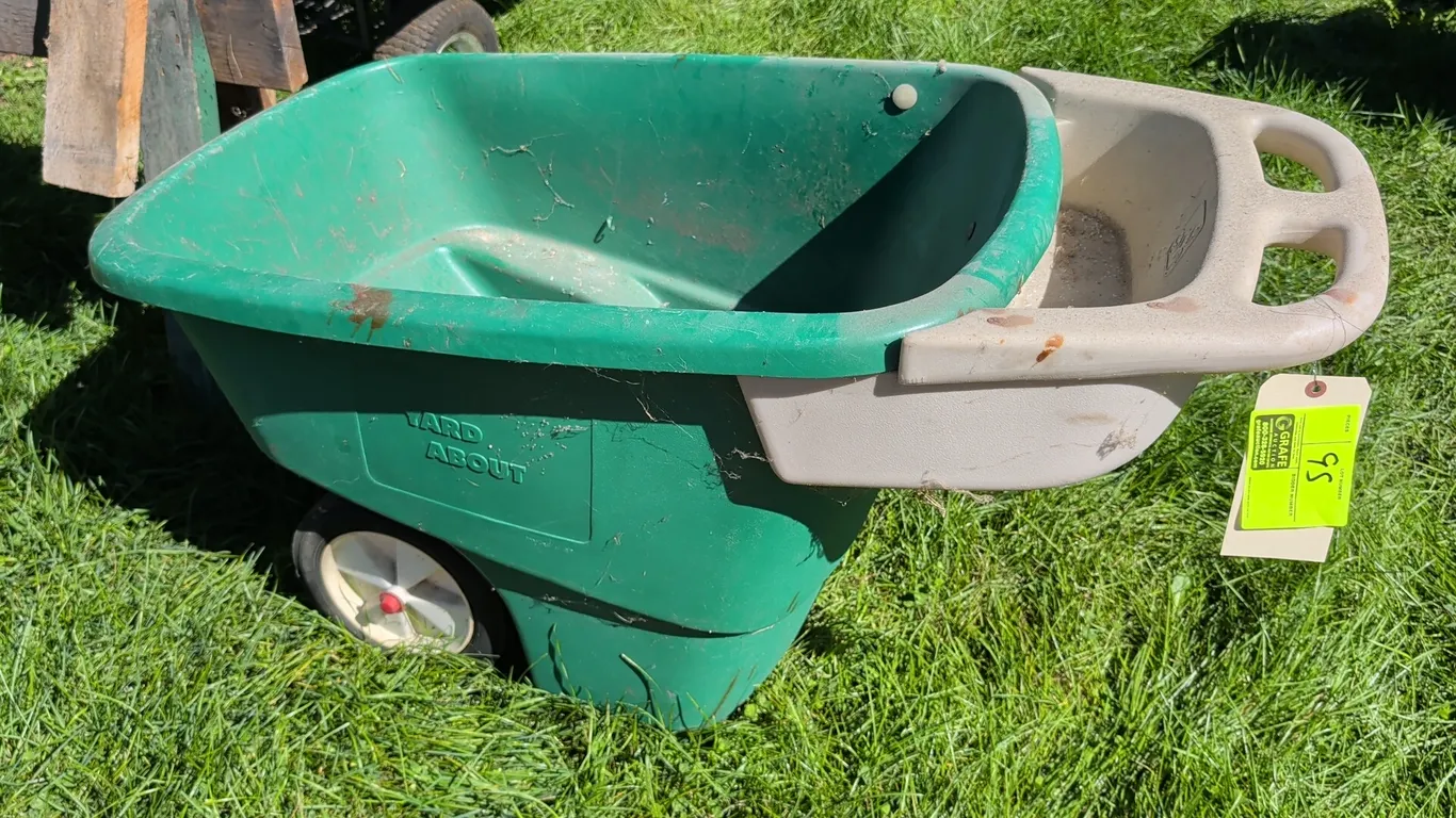 Step2 Yard About 2-wheel plastic yard cart. Features a molded green plastic tub, integrated beige handle with storage tray, and two wheels.