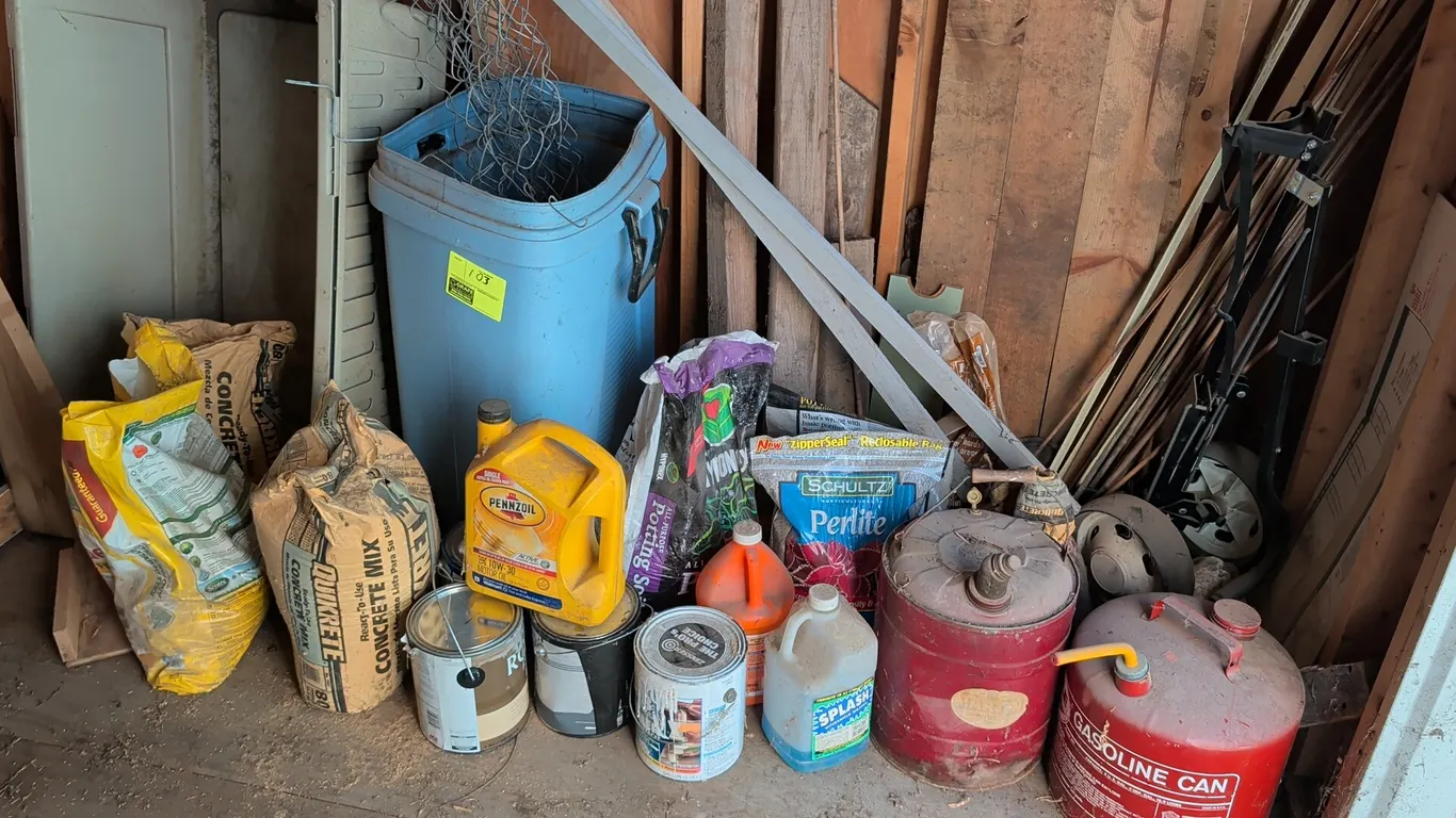 Assorted yard and workshop supplies. Includes (2) wooden sawhorses, (2) metal gasoline cans, plastic pet kennel shell, blue plastic utility can with w