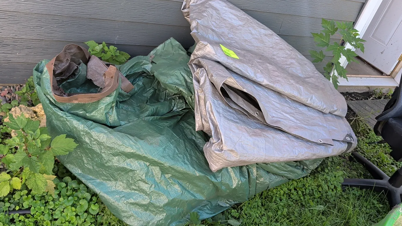 Pair of large tarps. Includes (1) silver tarp with metal grommets and (1) green tarp. Features woven polyethylene construction.
