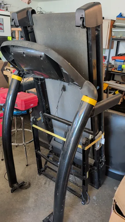 Livestrong folding treadmill. Features a folding deck, digital display console, integrated speakers, and MaxComfort adjustable cushioning. Mounted on