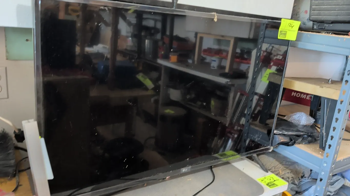 LG 44" television. Features flat panel display and power cord. Mounted on two-point stand legs.