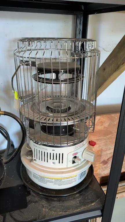 Dyna-Glo WK11C8 portable kerosene convection space heater. Features protective wire safety guard, glass chimney, wick adjustment knob, push-button shu