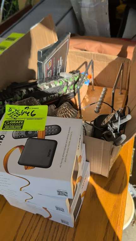 Assortment of household items, electronics, and furniture. Includes (3) boxed Xumo Stream Boxes, gray upholstered recliner, brown vinyl garment bag, (