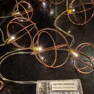 Battery-operated decorative string lights warm white LED bulbs enclosed in geometric copper-colored