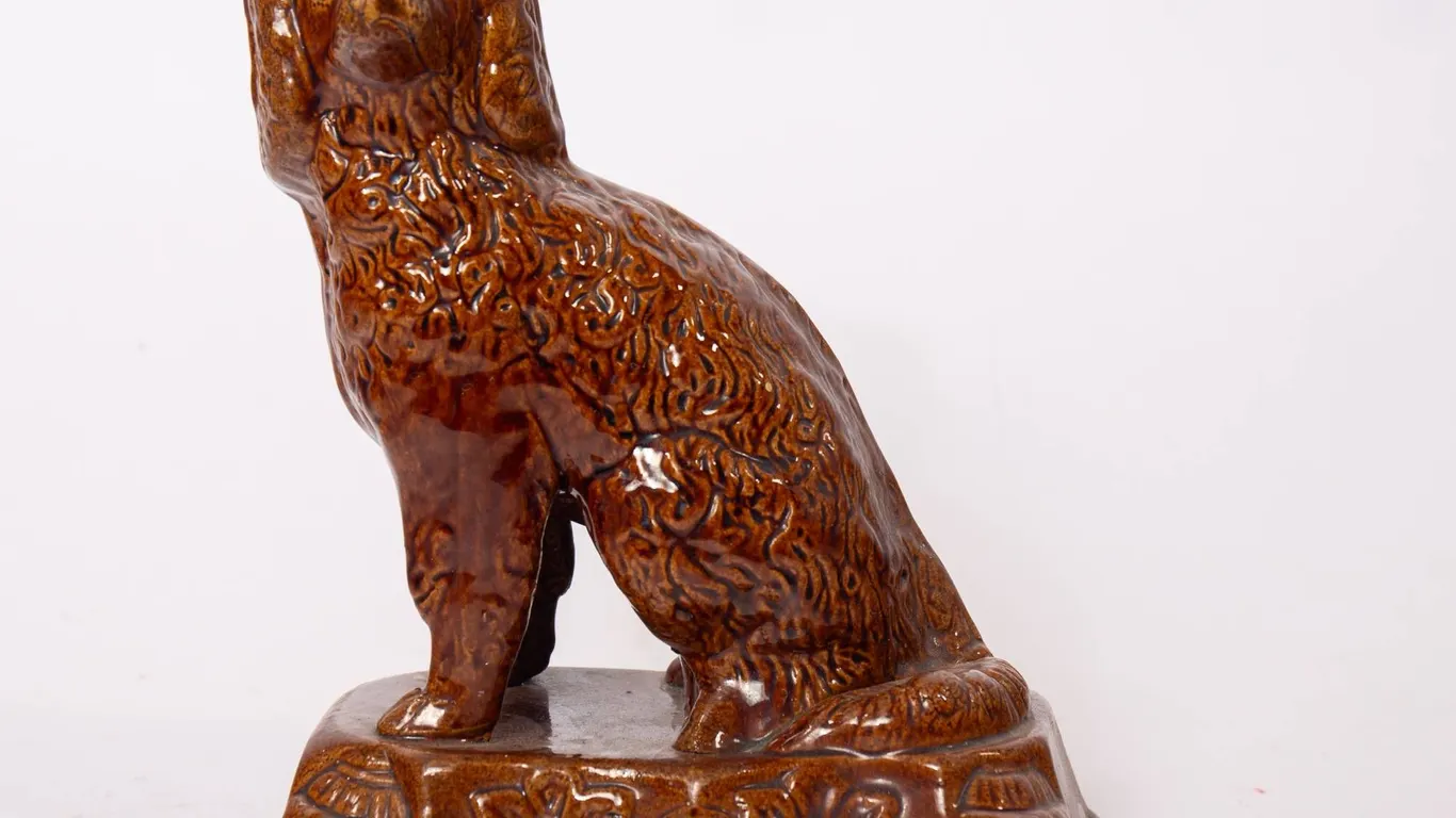 ROCKINGHAM SPANIEL FIGURE IN BROWN GLAZE.