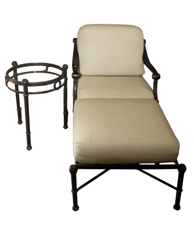 BLACK ALUMINUM CHAIR, OTTOMAN, AND ROUND GLASS-TOP TABLE.