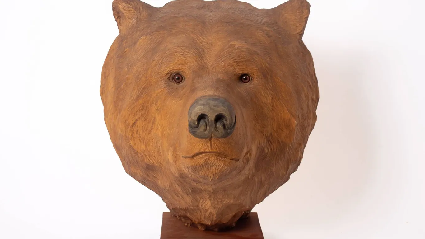 LARGE CARVED BEAR HEAD ON WOOD BASE.