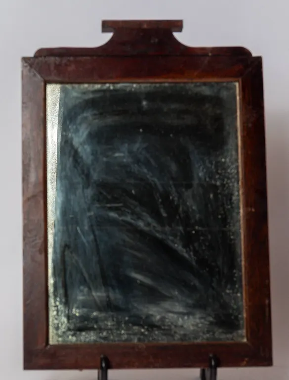 WOODEN FRAMED MIRROR WITH DECORATIVE TOP.