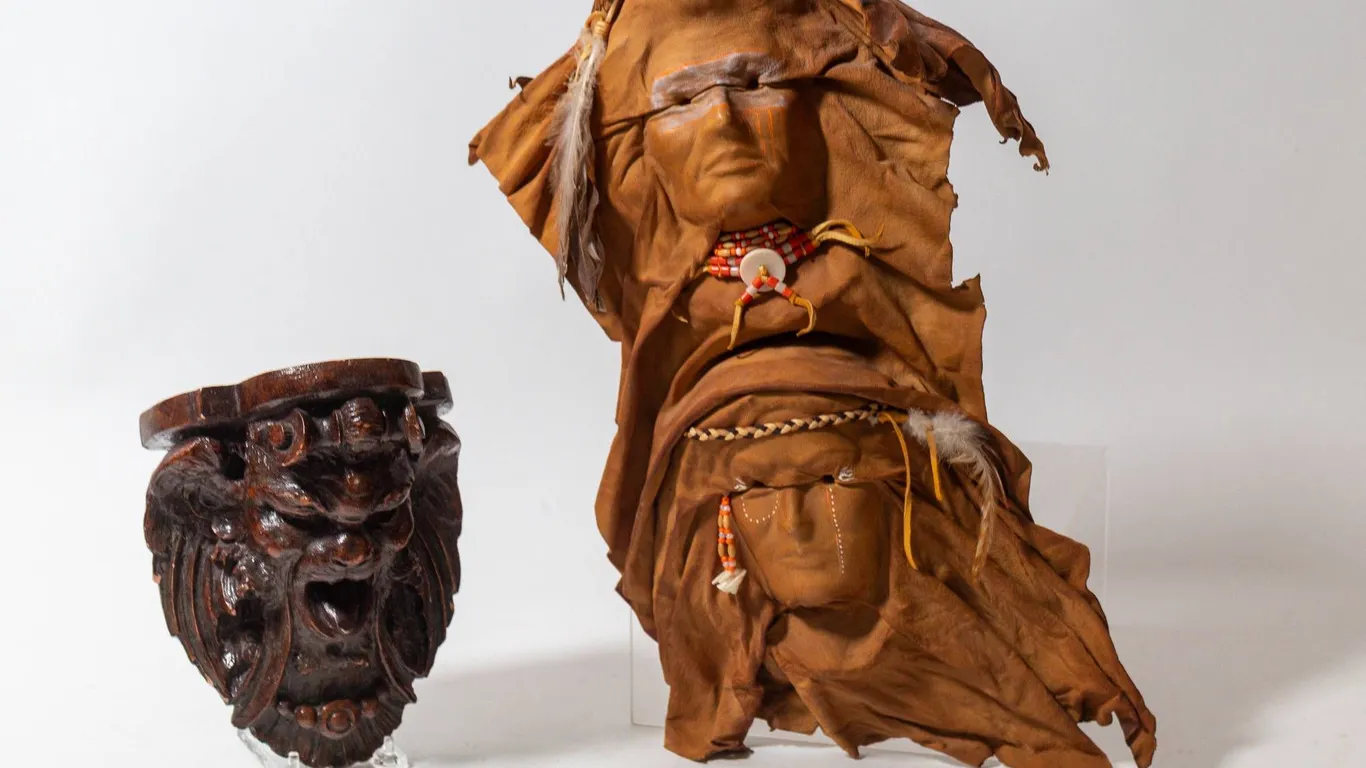 HANDCRAFTED LEATHER WALL HANGING AND TERRA COTTA MASK PIECE.
