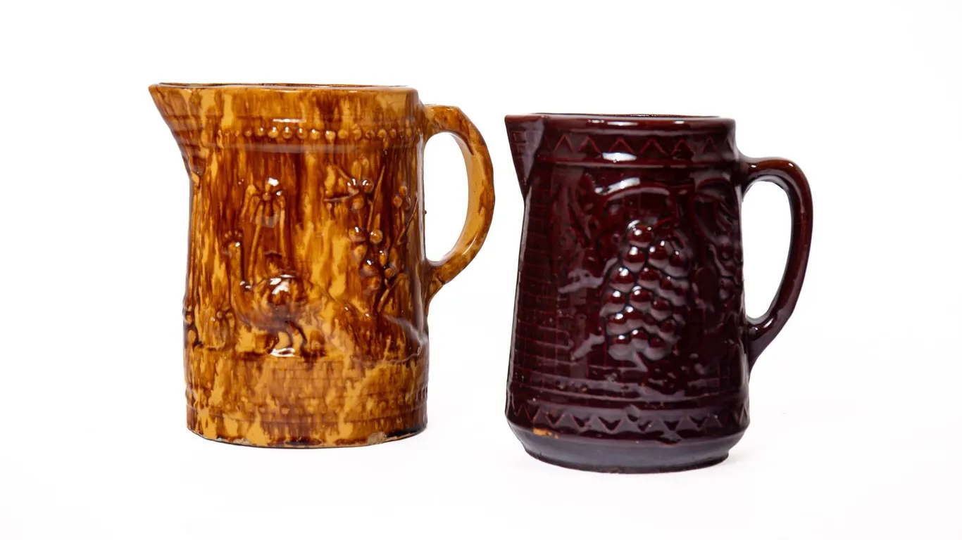 YELLOW WARE PITCHER AND BROWN GLAZED STONEWARE PITCHER.